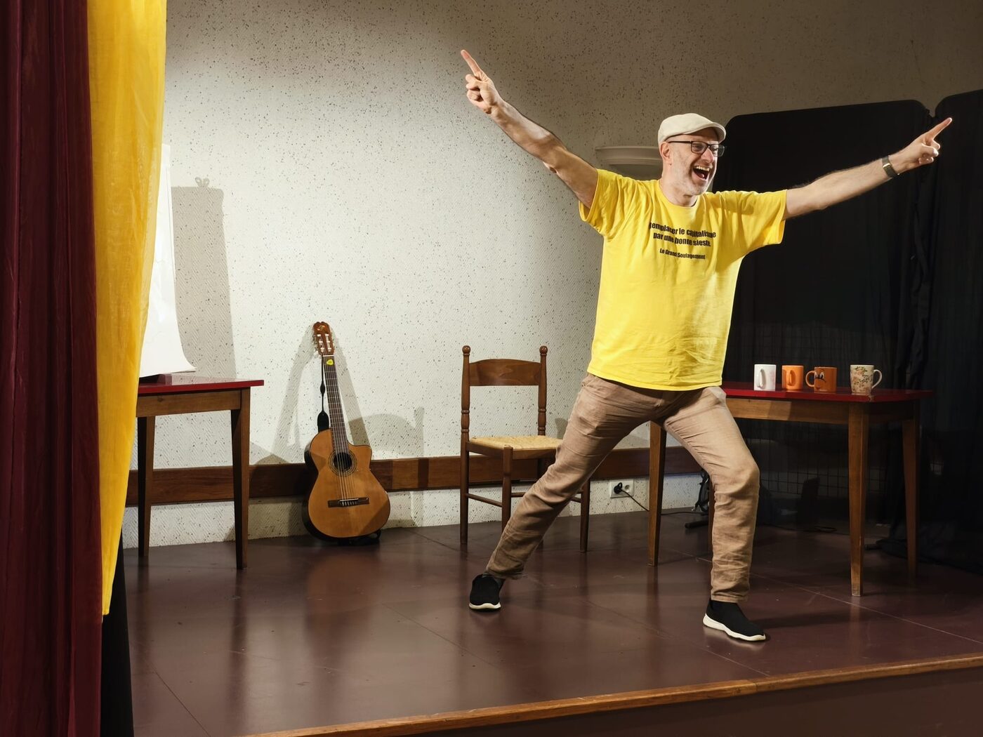 Robi sur scène, avec tee-shirt jaune, une casquette, et d'humeur up.